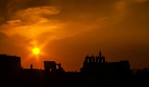 Silhouette of built structure at sunset