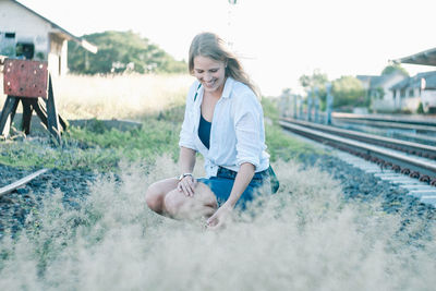 Woman sitting on railroad track