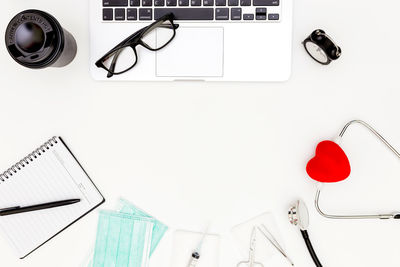 Directly above shot of eyeglasses on table against white background