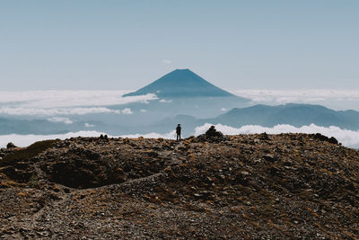 Hiker standing on mountain peak against sky
