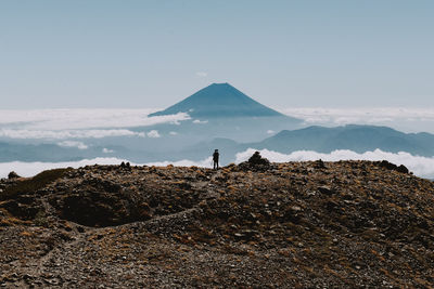 Hiker standing on mountain peak against sky