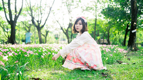 Young woman with pink flowers in garden