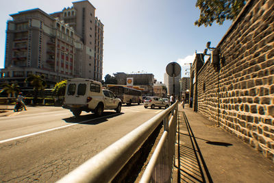 Cars on city street against sky