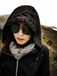 Portrait of young woman wearing sunglasses against sky