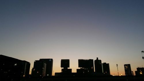 Modern buildings against clear sky during sunset