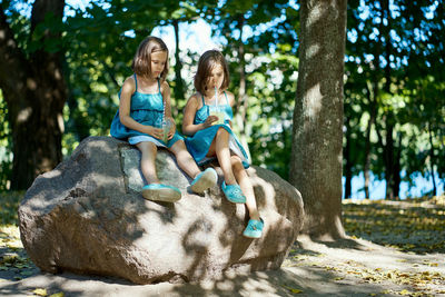 Two little girls drinking lemonade in park