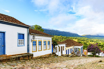 Street with old colonial houses in tiradentes city and the hills in background