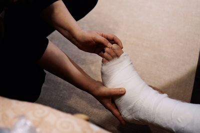 Midsection of woman adjusting broken leg