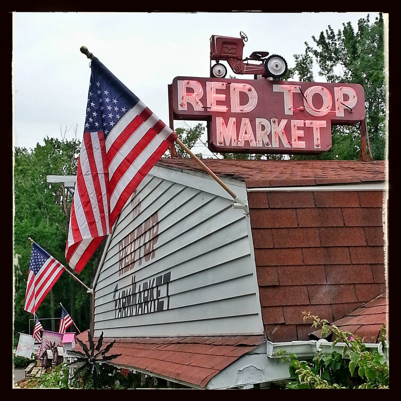 red, transfer print, building exterior, flag, patriotism, built structure, architecture, text, american flag, national flag, western script, auto post production filter, communication, identity, day, sunlight, guidance, outdoors, low angle view, clear sky