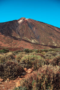 Scenic view of mountains against clear blue sky