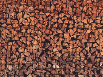 Full frame shot of firewood with metallic fence