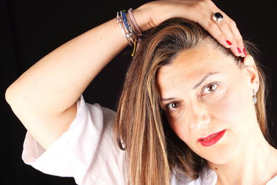 Close-up portrait of young woman against black background