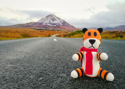 Toy car on road by mountains against sky