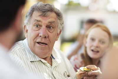 Senior man socializing on a garden party