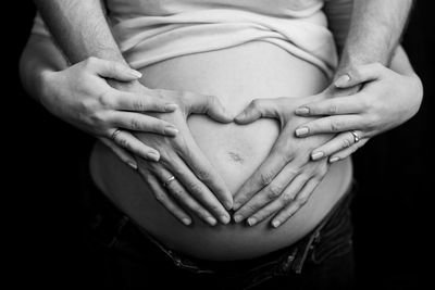 Midsection of woman touching finger