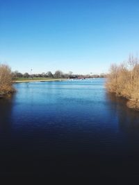 Scenic view of lake against clear blue sky