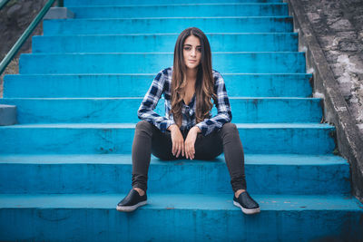 Portrait of young woman sitting on staircase