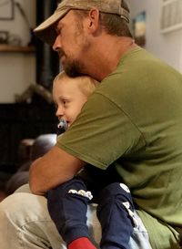 Father and son sitting on baby