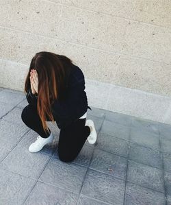 Woman praying on footpath