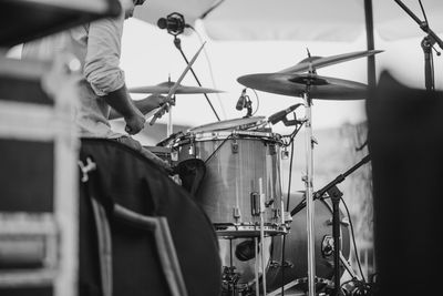 Midsection of man playing drum set