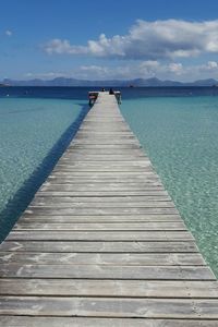 View of jetty in sea against cloudy sky