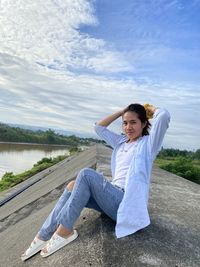 Rear view of young woman standing against sky