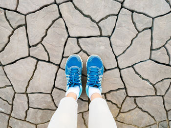 Low section of woman standing on drought land