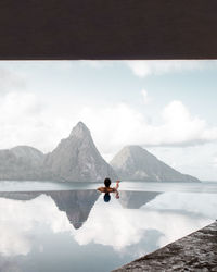 Rear view of man in infinite pool