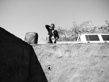 Man standing against wall against clear sky