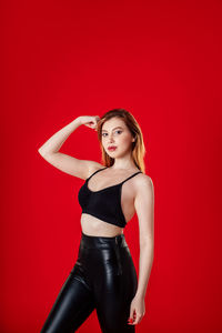 Portrait of a beautiful young woman against red background