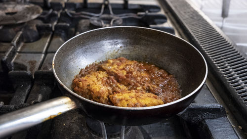 Preparation of meat stew with cooking pan on the stove, italy