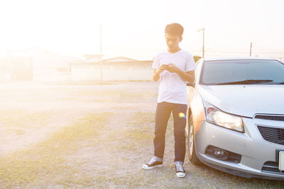 Full length portrait of mid adult man standing on car