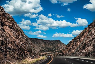 Road amidst mountains against sky