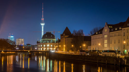 Illuminated bridge over river at night