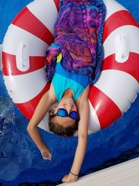 Directly above shot of girl lying on inflatable ring in pool