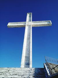 Low angle view of cross against clear blue sky