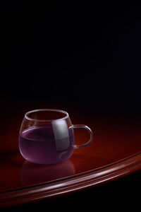 Close-up of tea cup on table against black background