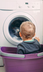 Rear view of boy looking at camera