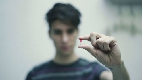 Young man holding capsule