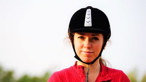 Portrait of woman in helmet against clear sky