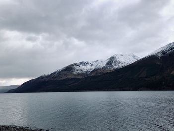 Scenic view of snowcapped mountains by sea against sky