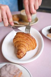 Cropped hand of person preparing food on table