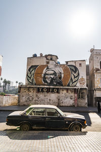 Vintage car on street against buildings in city against sky