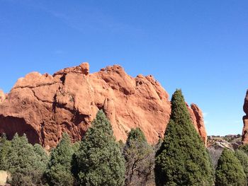 Low angle view of rocks against blue sky