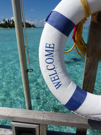 Close-up of text on railing against sea