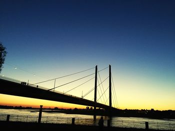 Silhouette bridge against clear sky at sunset