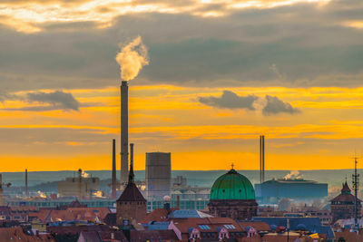 Smoke emitting from chimney against sky during sunset