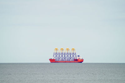 Container ship sailing on sea against clear sky