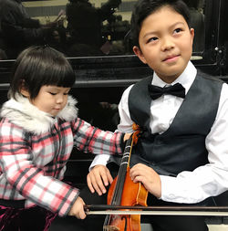 High angle view of siblings playing violin