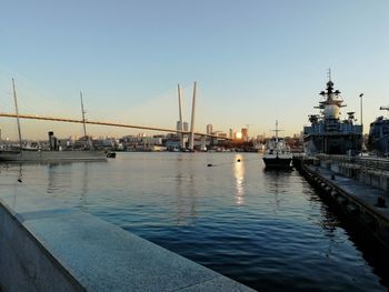 Sailboats moored in river against clear sky